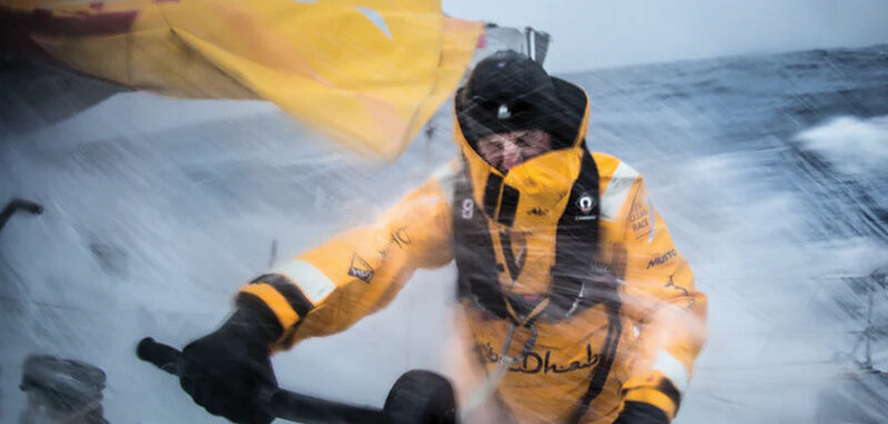 Sailor wearing lifejacket on yacht in bad weather